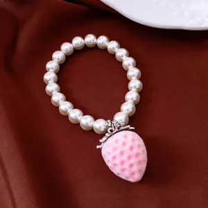 Elegant sweet pearl bracelet featuring a pink flocked strawberry pendant with zircon details.