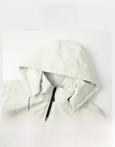 Detailed view of adjustable detachable hood and zipper on light grey outdoor jacket
