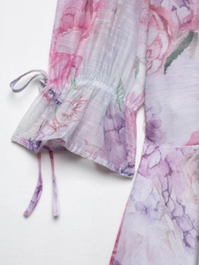 Détail de la manche d'une robe en mousseline fleurie avec poignet élastique et cordon