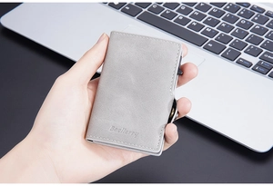 Close-up of slim RFID blocking grey leather card holder with card pop-up slider