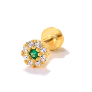 Macro view of gold flower stud earring with green gemstone and white diamond accents