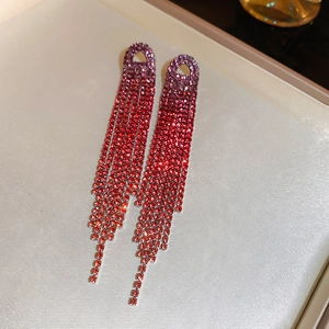Macro shot of long gradient rhinestone tassel earrings in purple and red hues