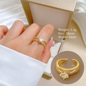 Detail of twisted gold crossover ring featuring sparkling zircon stones and warm tones