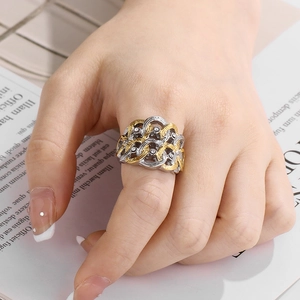 Gros plan d'une bague bicolore tressée avec diamants sur main avec arrière-plan de magazine