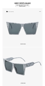 Detail view of square cat-eye sunglasses featuring grey spotted frames and dark lenses