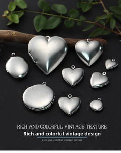 Vintage stainless steel heart and round locket pendants in various sizes on dark wood