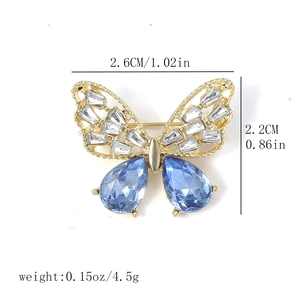 Detail view of gold butterfly brooch with blue crystals and size measurement labels