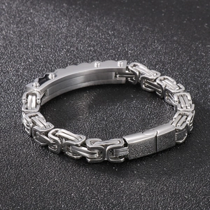 Detail of silver Byzantine chain bracelet with curved plaque on dark background