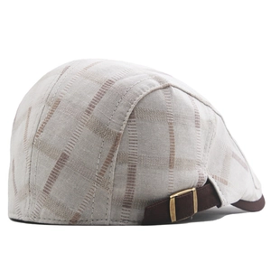 Detail of plaid cotton beret showing brown adjustable strap and bronze metal buckle