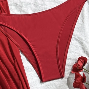 Detailed view of red bikini bottoms featuring precise double-needle stitching and smooth fabric