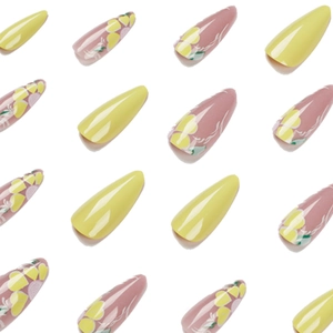 Long almond press-on nails featuring bright yellow floral designs and heart patterns