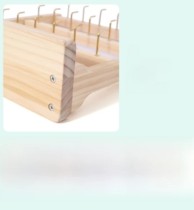 Detail of wooden jewelry organizer featuring golden metal hooks and natural wood grain finish