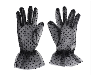 Detailed view of sheer black polka dot lace gloves with ruffled wrist trim and mesh texture