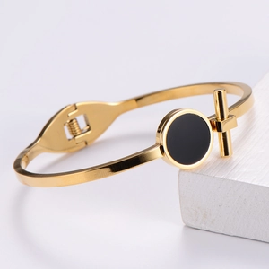 Minimalist gold titanium steel bangle with black circular inlay and T-bar accent decoration
