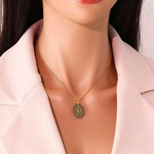 Gold stainless steel necklace with green oval stone pendant featuring a gold letter O