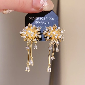 Detail of gold floral pearl earrings with long crystal tassels and 925 silver studs