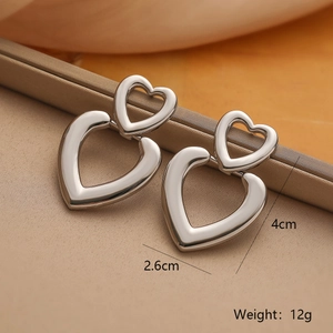Macro detail of silver geometric heart-shaped drop earrings with size measurements