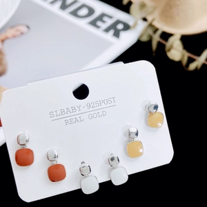Detailed view of three pairs of square enamel stud earrings on a 925 silver post card