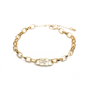 Detail of gold curb chain bracelet with a square zircon star charm on white background