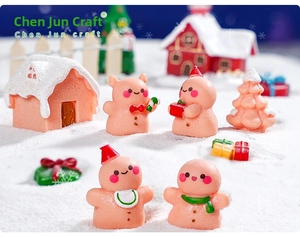 Miniature Christmas gingerbread man figurines and holiday resin decor in a snowy scene