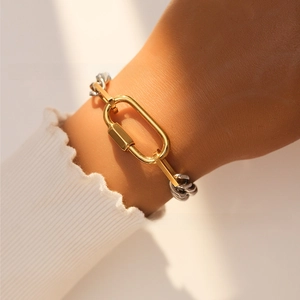 Detail of two-tone stainless steel Cuban chain bracelet with 18k gold clasp