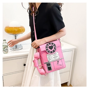 Pink retro telephone shoulder bag detail with black dial decoration and handset attachment