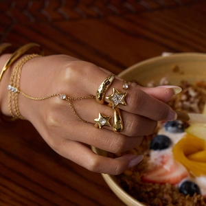 Close-up of gold star rings and hand-chain set with sparkling rhinestones on hand