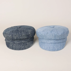 Detailed view of navy and light blue denim newsboy caps with textured fabric and buttons