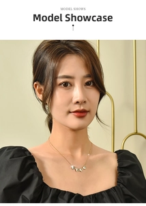 Model wearing gold clover necklace with heart-shaped mother of pearl pendants