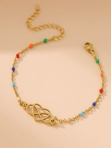 Macro detail of gold 18k Mobius heart bracelet with multi-color beads and lobster clasp
