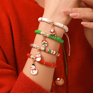 Gros plan de bracelets de Noël festifs avec pendentifs flocon et Père Noël au poignet