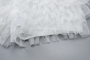 Dettaglio macro delle pieghe in rete bianca e della trama delicata del tessuto tulle