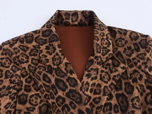 Detail of leopard print trench coat with wide notch lapels and textured fabric finish