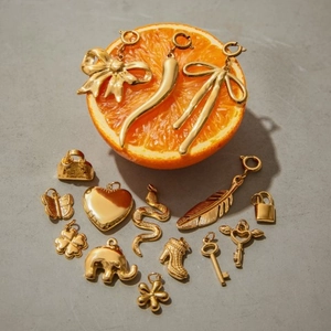 Detailed collection of assorted gold stainless steel charms on a concrete background