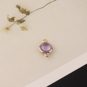 Macro detail of round purple crystal pendant with gold double rings for jewelry making