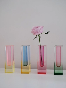 Detailed view of four colorful gradient acrylic rectangular vases on a white surface