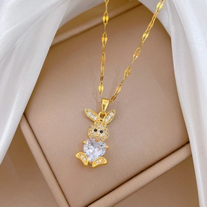 Dettaglio della collana con coniglio dorato e cristallo a cuore su seta bianca lucida