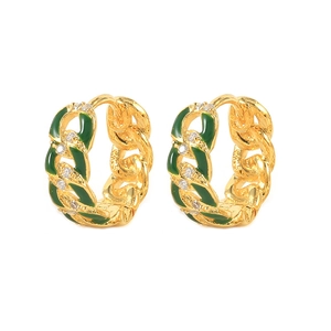Macro shot of gold-plated chain earrings with green enamel and sparkling zircon accents