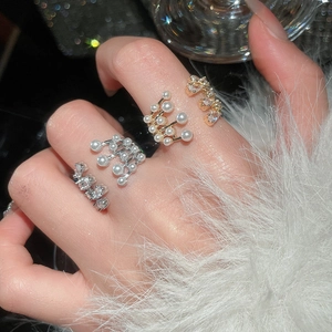 Detail of layered pearl and zircon open ring with elegant gold finish on female hand