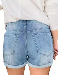 Rear view detail of denim shorts with distressed back pockets and folded hemline