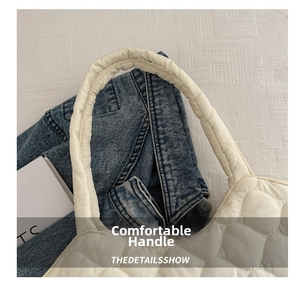 Close-up of the comfortable handle and quilted texture of the cream tote bucket bag