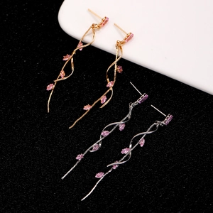 Macro detail of gold and silver spiral tassel earrings with pink marquise stones