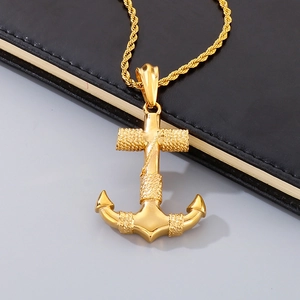 Polished gold anchor pendant necklace on black leather notebook, vintage steel jewelry