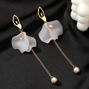 Elegant long fringe tassel earrings with frosted white petals and pearls on black fabric