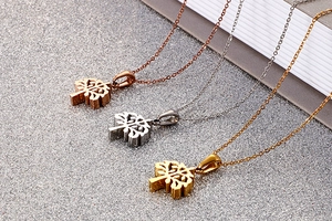 Detailed view of hollow tree of life pendants in rose gold, silver, and gold finishes