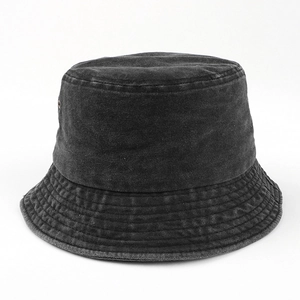 Detailed macro view of high-quality washed denim texture on a dark grey bucket hat