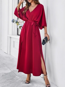 Detail view of red V-neck maxi dress with tie waist and side slit on soft fabric
