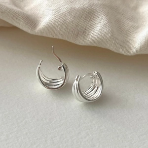 Close-up of 925 sterling silver geometric hoop earrings with textured grooved surface