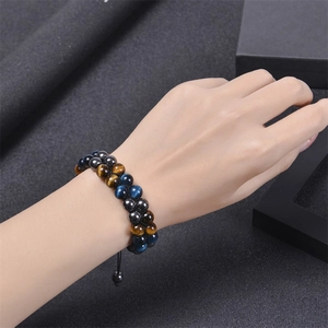 Detail of double-layer woven blue tiger eye stone and hematite beads on male wrist