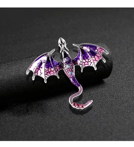 Macro shot of vintage dragon brooch with purple enamel wings and sparkling blue crystals